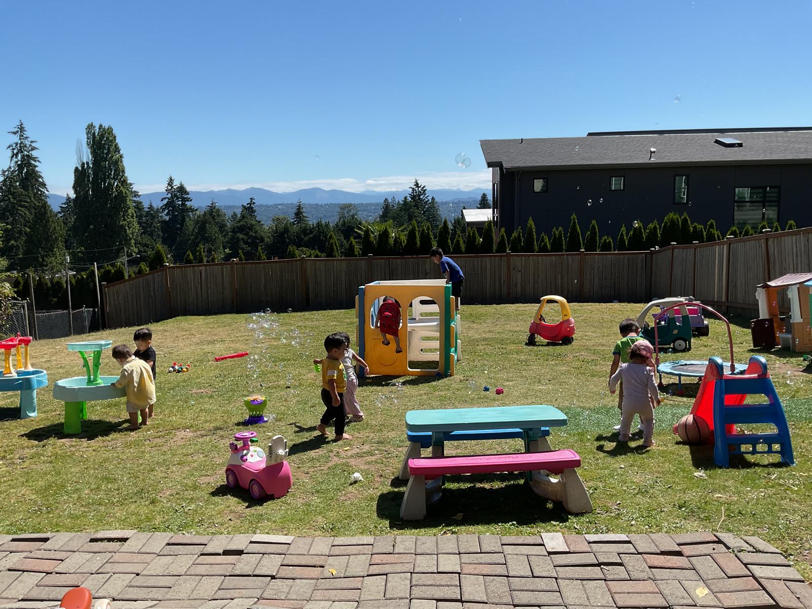 Children playing outside in the safe, fenced backyard playground