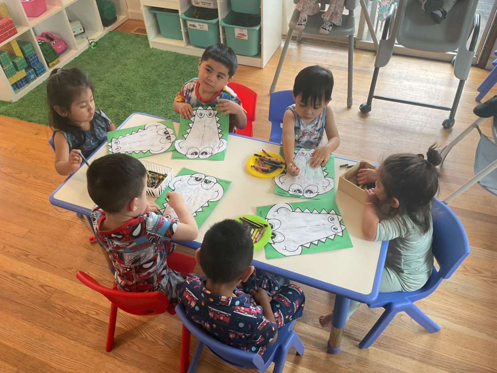 Children working together on a craft activity at the classroom tables